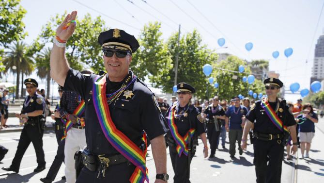 San Francisco Chief of Police Greg Suhr waves while marching with a number of his officers in the 44th annual Gay Pride parade Sunday, June 29, 2014, in San Francisco. The lesbian, gay, bisexual, and transgender celebration and parade is one of the largest LGBT gatherings in the nation. (AP Photo/Eric Risberg)